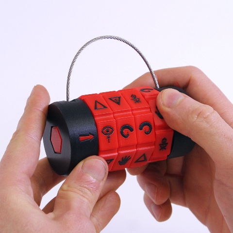 A custom-made padlock held in two hands with red dials and mysterious symbols for some kind of ritual.